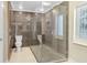 Modern bathroom featuring tiled walls, glass enclosed shower, tile floors, and modern toilet and fixtures at 8218 Borgia Ct, Orlando, FL 32836