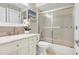 This bathroom features tile flooring, a vanity, a tub with sliding glass doors, and coordinated fixtures at 8218 Borgia Ct, Orlando, FL 32836