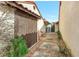 Side exterior of the house with a walkway, storage room, landscaping, and neutral color palette at 8218 Borgia Ct, Orlando, FL 32836