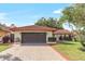 Charming one-story home featuring a brick driveway, two-car garage, and red tile roof at 8218 Borgia Ct, Orlando, FL 32836