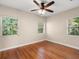 Sun-filled bedroom featuring gleaming hardwood floors and a modern ceiling fan at 85 Interlaken Rd, Orlando, FL 32804