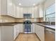 Well-lit kitchen with stainless steel appliances, granite counters and classic white cabinetry at 85 Interlaken Rd, Orlando, FL 32804