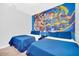 Comfortable bedroom featuring twin beds, gray walls and a cartoon mural for a playful atmosphere at 9017 Dogleg Dr, Davenport, FL 33896