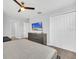 Bedroom with carpet, ceiling fan, television, double closet, and gray dresser at 9017 Dogleg Dr, Davenport, FL 33896