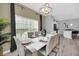 Bright dining area with a stylish chandelier, seating for eight, and an open layout at 9017 Dogleg Dr, Davenport, FL 33896