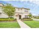 Inviting two-story home featuring lush landscaping and a welcoming front entrance at 9017 Dogleg Dr, Davenport, FL 33896