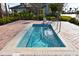 Private hot tub with a stone surround and stainless steel handrails for easy access at 9017 Dogleg Dr, Davenport, FL 33896