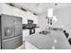 Modern kitchen boasts stainless steel appliances, gray countertops, and stylish pendant lighting at 9017 Dogleg Dr, Davenport, FL 33896