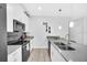 Modern kitchen featuring white cabinets, stainless steel appliances, and a large island with bar seating at 9017 Dogleg Dr, Davenport, FL 33896