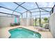 Inviting pool with enclosed screen, seating, and shaded umbrella area at 9017 Dogleg Dr, Davenport, FL 33896