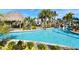 Community pool with a thatched-roof hut, waterslide, and tropical landscaping at 9017 Dogleg Dr, Davenport, FL 33896