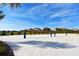 Sandy community volleyball court set against a backdrop of blue skies and lush landscaping at 9017 Dogleg Dr, Davenport, FL 33896