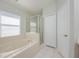 Relaxing bathroom featuring a soaking tub, glass-enclosed shower, and ample storage with a linen closet at 944 Glen Abbey Cir, Winter Springs, FL 32708