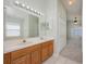 Bright bathroom featuring a double sink vanity and a large mirror with vanity lighting at 944 Glen Abbey Cir, Winter Springs, FL 32708