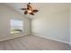 Well-lit bedroom boasts neutral carpet, ceiling fan, and a large window with view to outdoors at 944 Glen Abbey Cir, Winter Springs, FL 32708