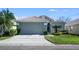 Charming single-story home showcasing a manicured lawn, tile roof, and a spacious two-car garage at 944 Glen Abbey Cir, Winter Springs, FL 32708