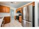 Modern kitchen showcasing stainless steel appliances, wood cabinets, and a seamless connection to the dining area at 944 Glen Abbey Cir, Winter Springs, FL 32708