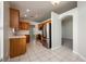 Well-lit kitchen with stainless steel appliances, wood cabinetry, and tile flooring leading to the living area at 944 Glen Abbey Cir, Winter Springs, FL 32708