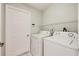 Bright laundry room equipped with a washer, dryer, and shelving for ample storage at 944 Glen Abbey Cir, Winter Springs, FL 32708