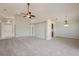 Open living room with neutral paint, carpet, and fan, leading to entry and kitchen area at 944 Glen Abbey Cir, Winter Springs, FL 32708