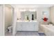 Bright Primary bath featuring dual sinks, white cabinets, and a soaking tub at 1100 Downswing Pl, Davenport, FL 33896