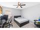 Cozy bedroom features a comfortable bed, a ceiling fan, and a nearby desk area, bathed in natural light at 1100 Downswing Pl, Davenport, FL 33896