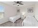 Charming bedroom features twin beds, bedside tables with lamps, and bright natural light from a large window at 1100 Downswing Pl, Davenport, FL 33896