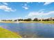 Scenic community pond featuring a fountain, lush greenery, and residential homes in the background at 1100 Downswing Pl, Davenport, FL 33896
