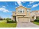 Inviting two-story home featuring a well-manicured lawn and a spacious two-car garage at 1100 Downswing Pl, Davenport, FL 33896