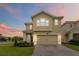 Charming two-story home with a well-manicured lawn, paver driveway and a welcoming facade with elegant details at 1100 Downswing Pl, Davenport, FL 33896