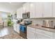 Well-equipped kitchen with white cabinets, stainless steel appliances, and stylish gray backsplash at 1100 Downswing Pl, Davenport, FL 33896