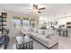 Bright and airy living room featuring a comfortable white sofa, ceiling fan, and views into the kitchen at 1100 Downswing Pl, Davenport, FL 33896