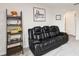 Comfortable living room featuring a black leather couch and decorative shelving at 1100 Downswing Pl, Davenport, FL 33896