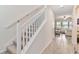 Carpeted staircase with white railing leading to the upper level and a view of the living room at 1100 Downswing Pl, Davenport, FL 33896