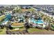 Aerial view of the community water park, featuring pools, slides, a splash pad, cabanas, and landscaped grounds at 1100 Downswing Pl, Davenport, FL 33896