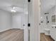 Bright bedroom with wood floors, a ceiling fan, and a bathroom featuring white vanity and tiled shower at 1102 Brielle Ct, Oviedo, FL 32765