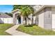 Front yard of house with palm tree, grass, walkway and blue door at 1102 Brielle Ct, Oviedo, FL 32765