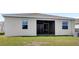 View of the rear of the house showing the screened patio and well maintained lawn at 1443 Lassen St, Haines City, FL 33844