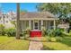 Charming home featuring a quaint front porch and vibrant red stairs nestled in a lush green yard at 204 Park Lake St, Orlando, FL 32803