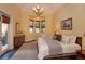 Bright main bedroom with a chandelier, bay window, and ensuite pool access for a luxurious and relaxing retreat at 2102 Sturbridge Ct, Winter Springs, FL 32708