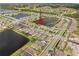 Aerial view of the community featuring a central lake and perfectly aligned homes at 211 Venetian Palms Blvd, New Smyrna Beach, FL 32168