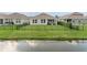 View of the backyard featuring a well-manicured lawn and tranquil pond at 211 Venetian Palms Blvd, New Smyrna Beach, FL 32168