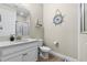 Nautical-themed bathroom with wood-look flooring and a white vanity with a marble countertop, offering a charming design at 211 Venetian Palms Blvd, New Smyrna Beach, FL 32168