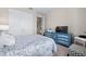 Comfortable bedroom featuring a patterned bedspread, a painted dresser, and large windows for natural light at 211 Venetian Palms Blvd, New Smyrna Beach, FL 32168
