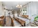 Bright dining area featuring hardwood floors, modern chandelier, and seamless flow to the kitchen and living spaces at 211 Venetian Palms Blvd, New Smyrna Beach, FL 32168