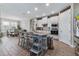 Modern kitchen with white cabinets, stainless steel appliances, island with seating, and wood-look tile floors at 211 Venetian Palms Blvd, New Smyrna Beach, FL 32168