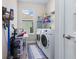 Well-equipped laundry room with modern washer and dryer, ample storage, and natural light from the window at 211 Venetian Palms Blvd, New Smyrna Beach, FL 32168