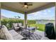 Relaxing covered patio with comfortable seating overlooking the lake at 211 Venetian Palms Blvd, New Smyrna Beach, FL 32168