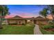 Charming single-story home featuring lush landscaping, stone accents, and a welcoming walkway at 221 W Berkshire Cir, Longwood, FL 32779