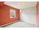 Bedroom with neutral carpet, window, and orange accent wall at 224 Lewfield Cir, Winter Park, FL 32792